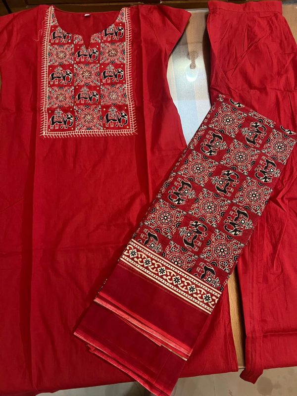 A vibrant red ethnic outfit featuring intricate elephant embroidery on the kurta, accompanied by matching pants and a patterned scarf.