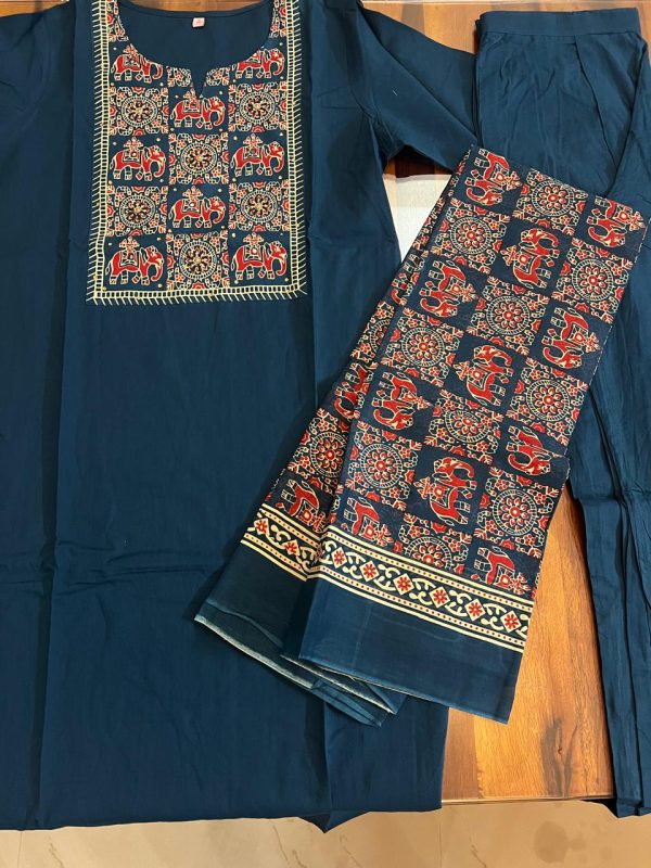 A navy blue kurta with intricate elephant motif embroidery on the neckline and matching patterned pants displayed on a wooden surface.